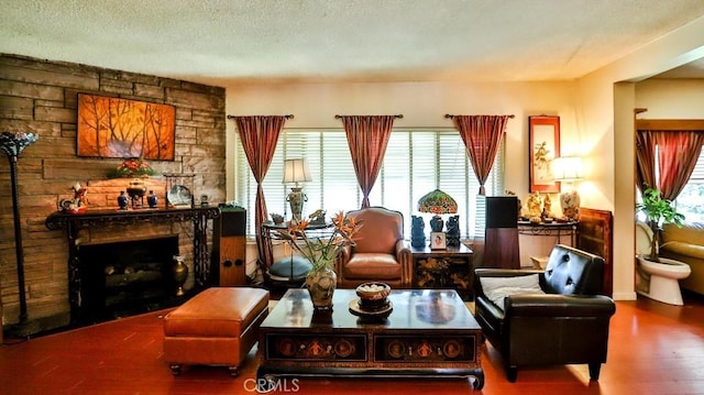 sitting room featuring a textured ceiling, a fireplace, and wood finished floors