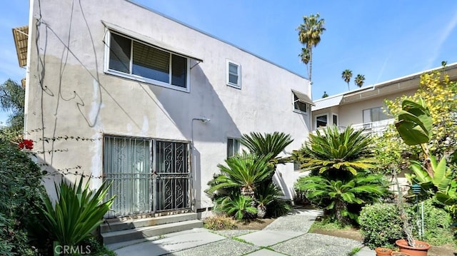 rear view of house with stucco siding