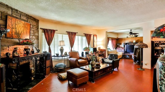 living room with a textured ceiling, a ceiling fan, and wood finished floors