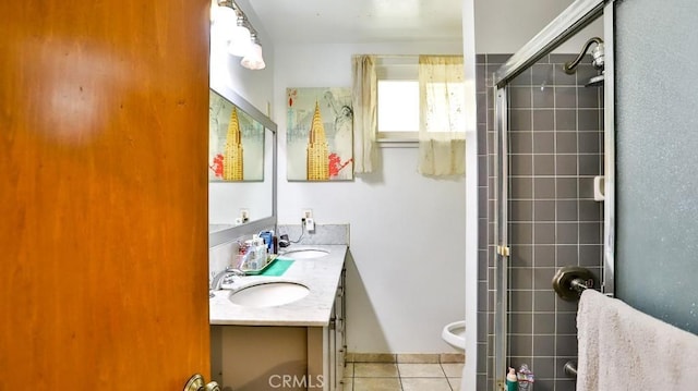 full bathroom with double vanity, tiled shower, tile patterned flooring, and a sink