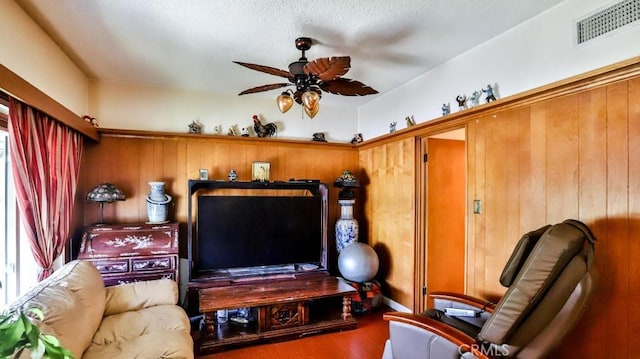 sitting room with visible vents, a ceiling fan, and wood finished floors