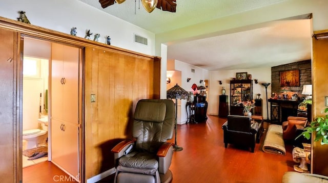 living area featuring visible vents, ceiling fan, and wood finished floors