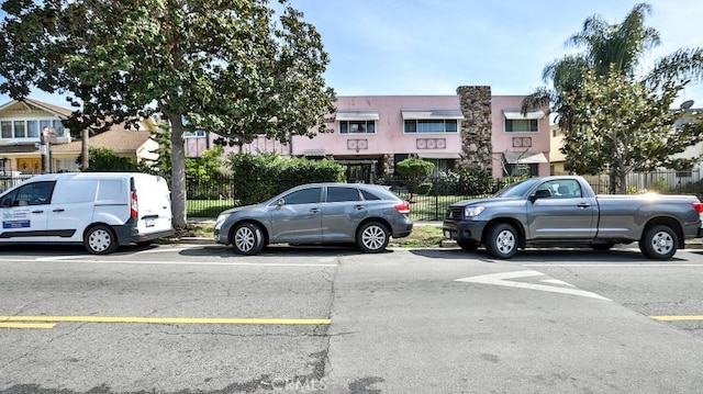 view of parking / parking lot featuring fence