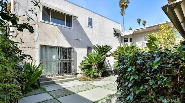 doorway to property featuring stucco siding