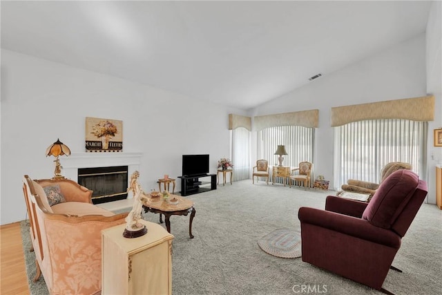 carpeted living room featuring high vaulted ceiling