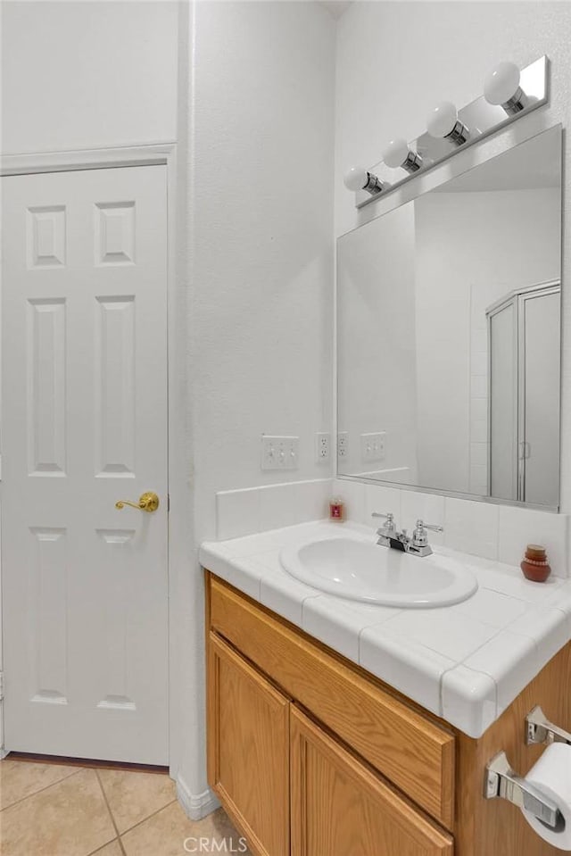 bathroom featuring vanity, tile patterned floors, and walk in shower