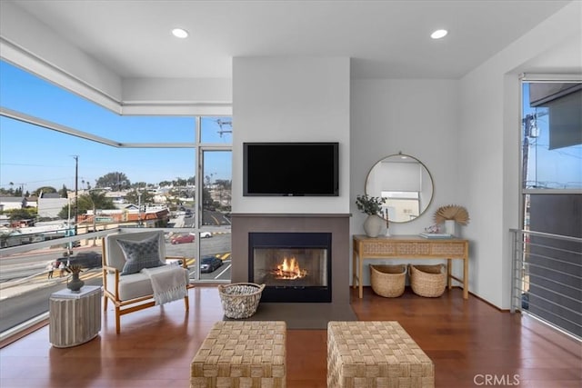 sitting room with recessed lighting, dark wood-style floors, and a fireplace with flush hearth