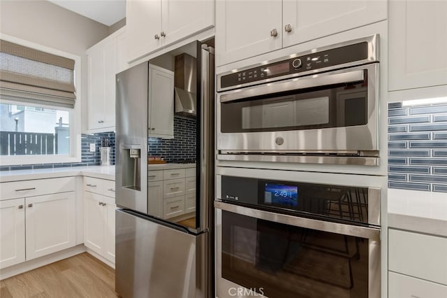 27717 Knoll View Pl, Valencia, CA 91381 - kitchen featuring light countertops, appliances with stainless steel finishes, decorative backsplash, and white cabinets