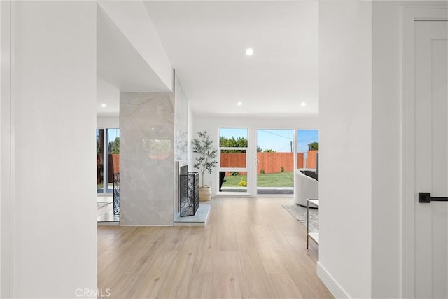 corridor featuring a wealth of natural light, light wood-style flooring, and recessed lighting