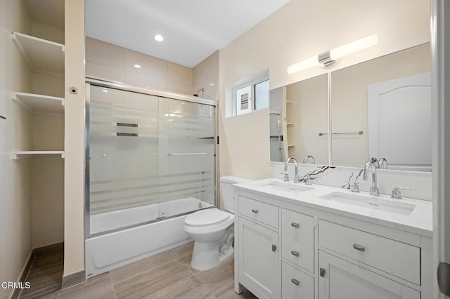 full bathroom featuring shower / bath combination with glass door, vanity, and toilet