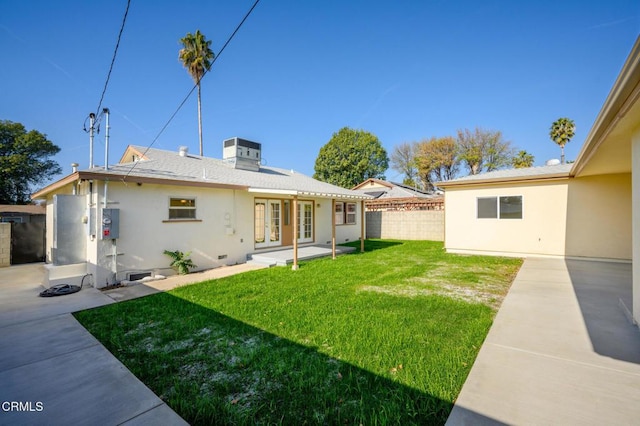 rear view of property with a patio, french doors, and a lawn