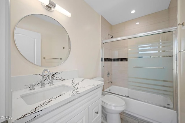 full bathroom featuring bath / shower combo with glass door, vanity, and toilet