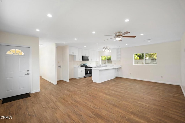 kitchen featuring appliances with stainless steel finishes, ceiling fan, light wood-type flooring, white cabinetry, and kitchen peninsula