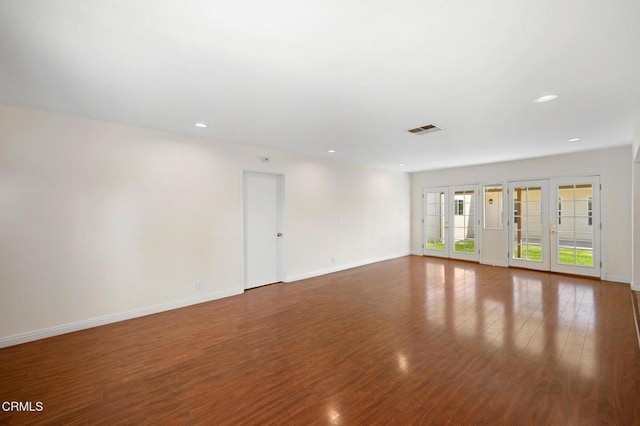 spare room featuring french doors and wood-type flooring