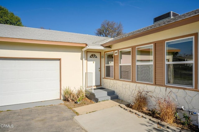 doorway to property featuring central AC and a garage