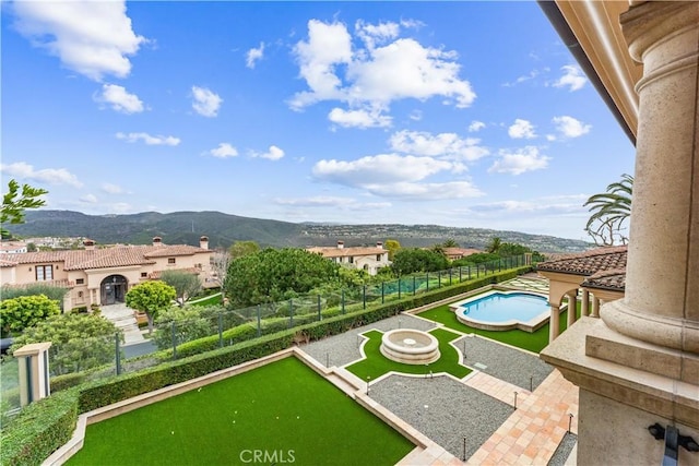 view of community with a fenced backyard and a mountain view