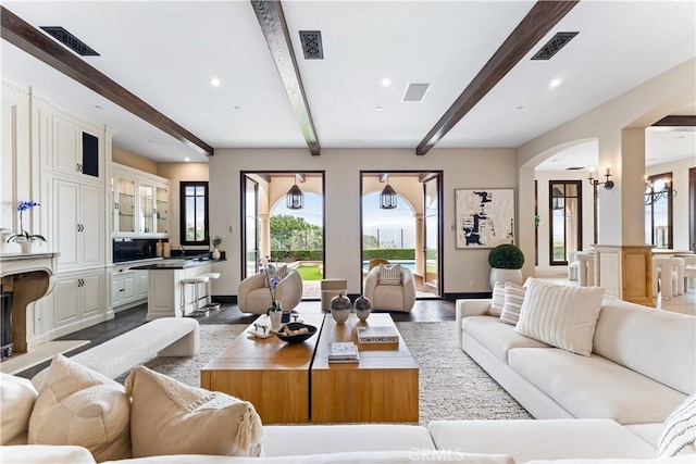 living room with beamed ceiling and visible vents