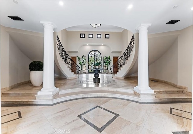 foyer entrance featuring marble finish floor, decorative columns, stairway, and baseboards