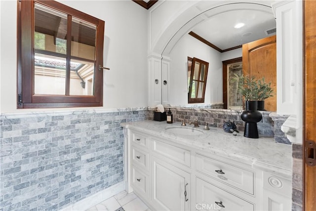 bathroom featuring tile walls, visible vents, marble finish floor, wainscoting, and crown molding