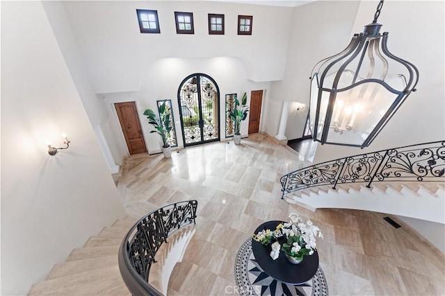 foyer entrance with stairs and a high ceiling