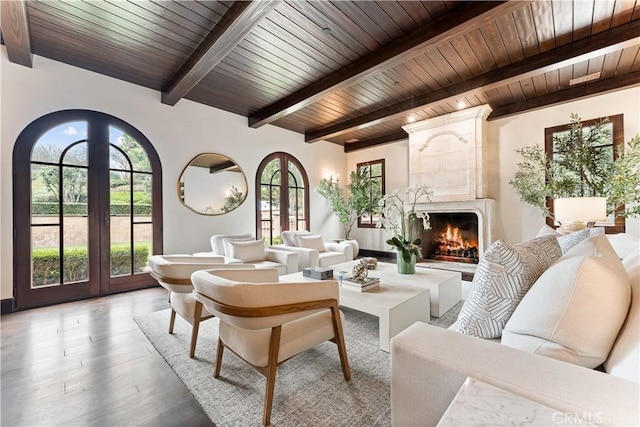 living area with light wood finished floors, wooden ceiling, beamed ceiling, french doors, and a fireplace