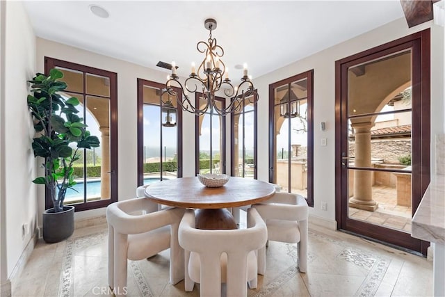 dining area featuring baseboards and a chandelier