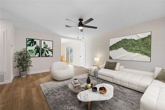 living room featuring dark wood-type flooring and ceiling fan