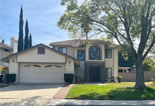 traditional-style house featuring an attached garage, fence, driveway, stone siding, and a front yard