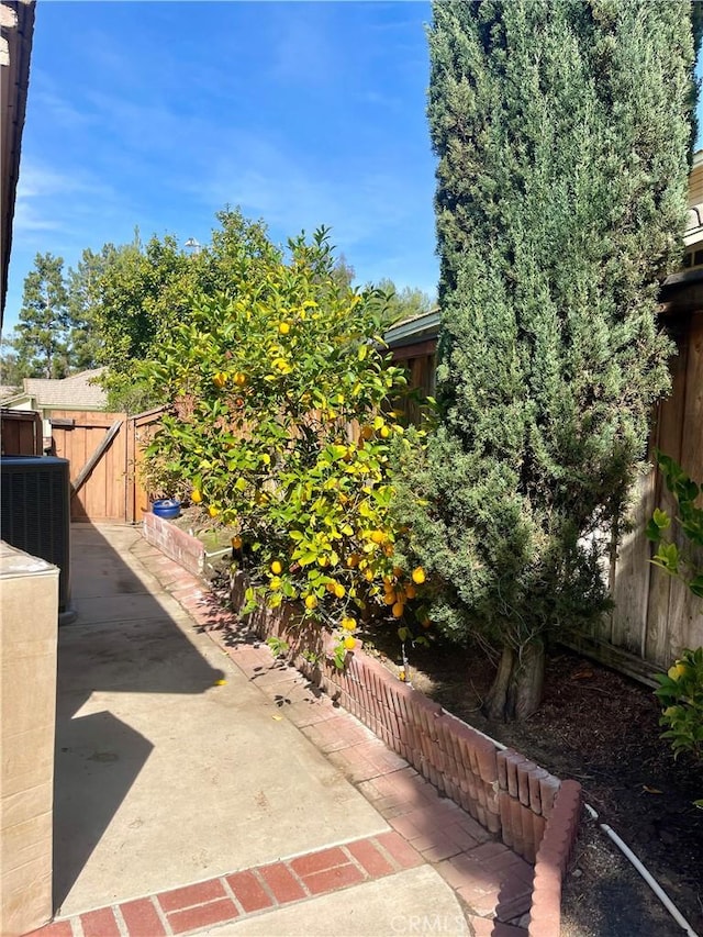 view of patio with cooling unit and fence