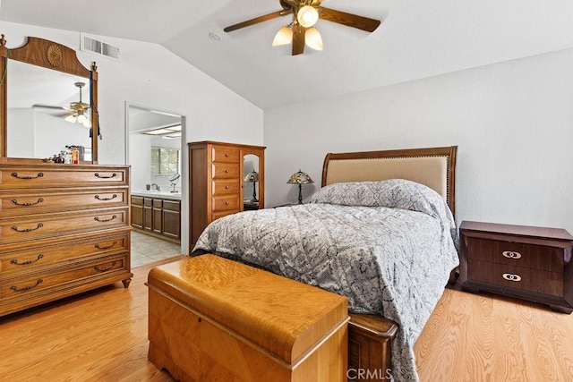 bedroom with visible vents, a sink, light wood-style flooring, and lofted ceiling