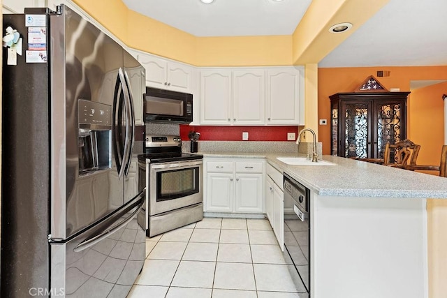 kitchen with a peninsula, light countertops, white cabinetry, black appliances, and a sink