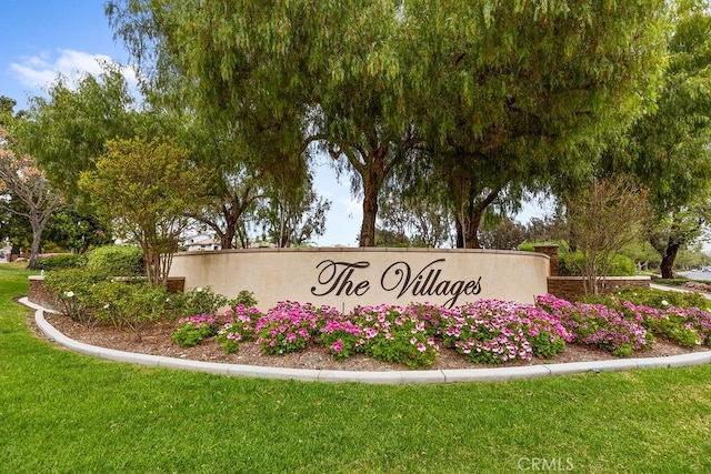 community / neighborhood sign featuring a lawn