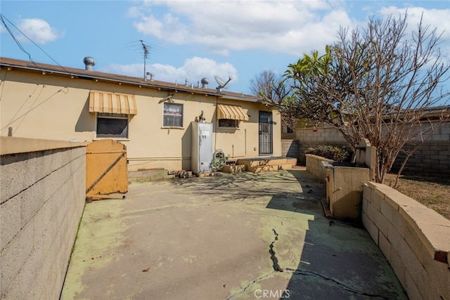 rear view of property featuring a patio and fence