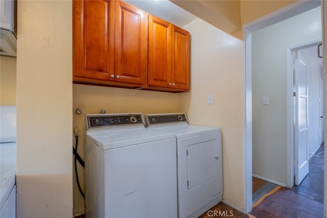 clothes washing area with cabinet space, independent washer and dryer, and baseboards