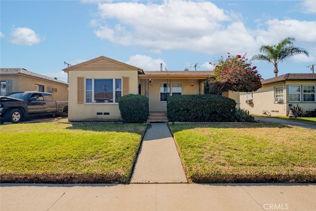 ranch-style house featuring a front lawn and stucco siding