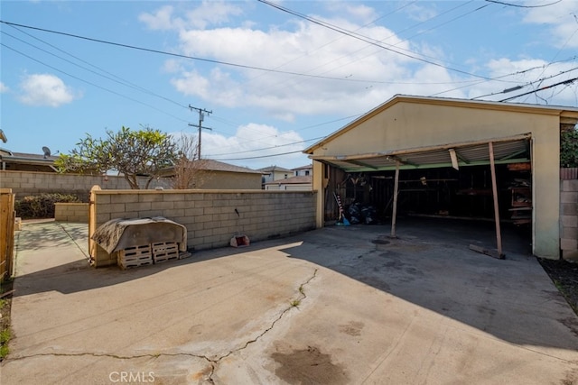 view of parking with a garage and fence