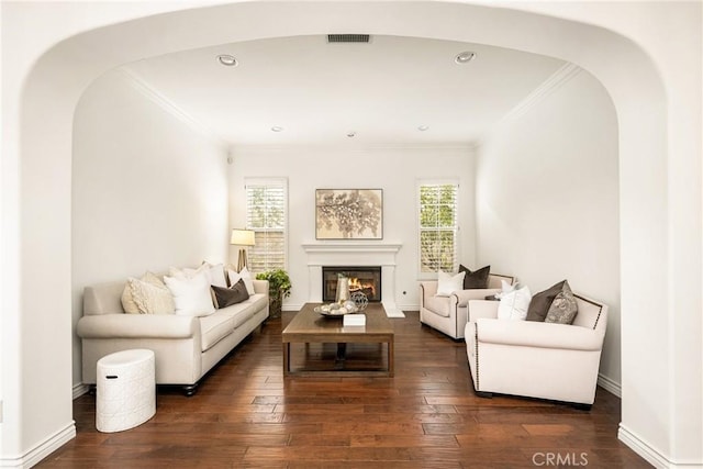 living room featuring dark wood-style floors, ornamental molding, and baseboards