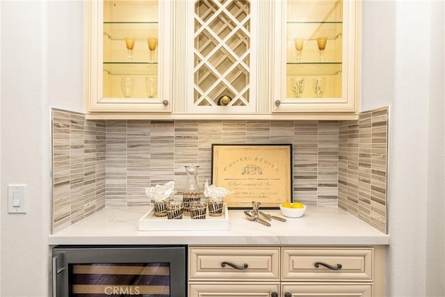 bar with beverage cooler, a bar, and tasteful backsplash