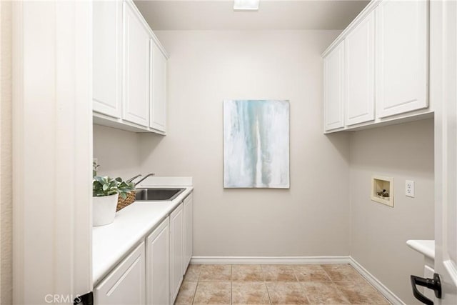 laundry area with cabinet space, light tile patterned floors, baseboards, hookup for a washing machine, and a sink