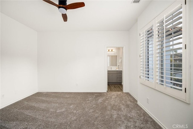 unfurnished bedroom with carpet, visible vents, a ceiling fan, ensuite bath, and baseboards