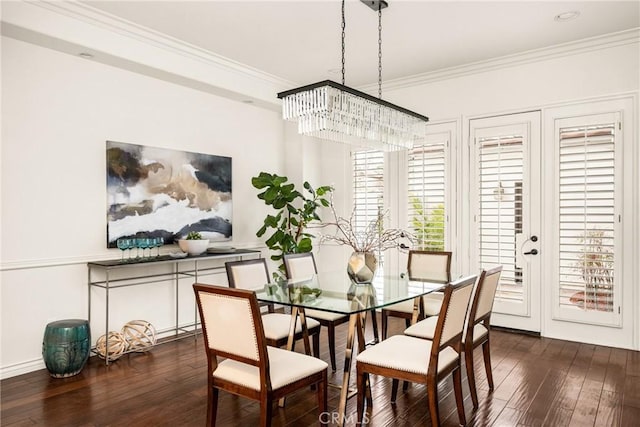 dining area with an inviting chandelier, ornamental molding, and dark wood finished floors