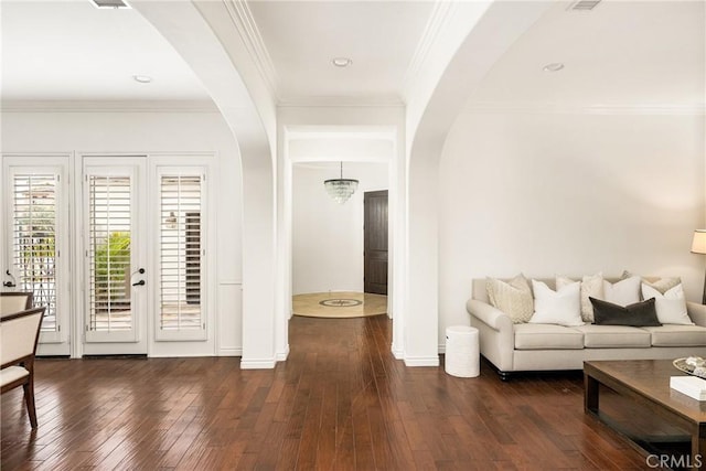 interior space featuring arched walkways, dark wood-type flooring, ornamental molding, and baseboards