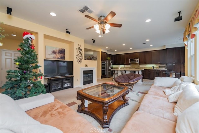 living room featuring ceiling fan and light carpet