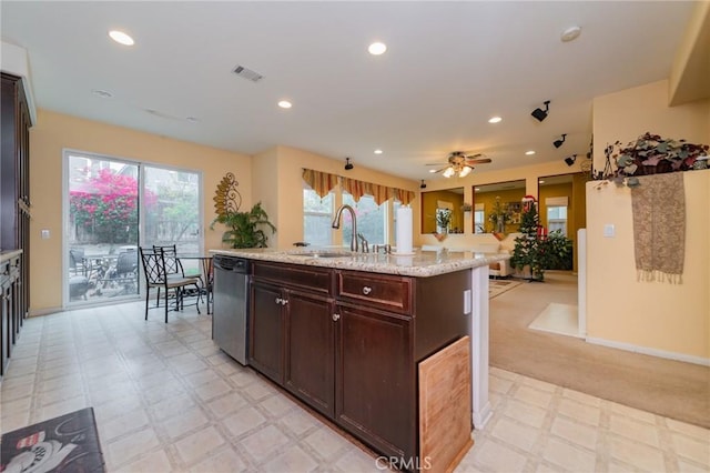 kitchen featuring sink, light stone countertops, stainless steel dishwasher, an island with sink, and dark brown cabinetry