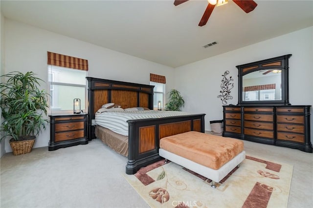 carpeted bedroom with multiple windows and ceiling fan