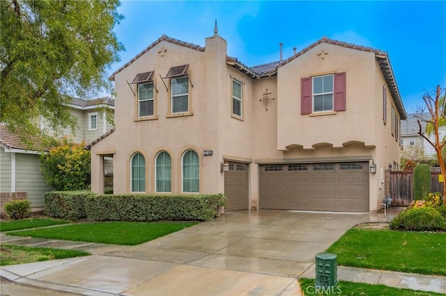 mediterranean / spanish house featuring stucco siding, concrete driveway, and an attached garage