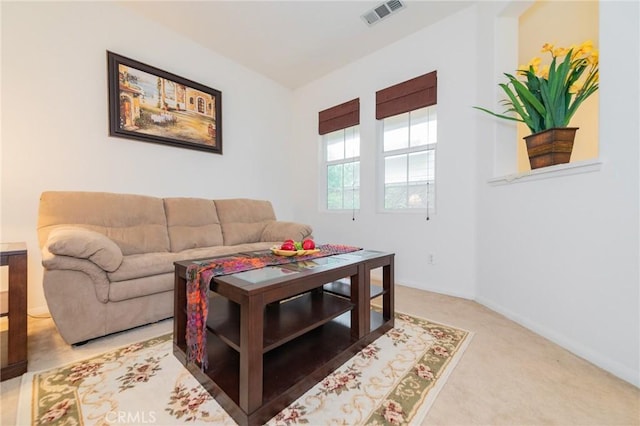 living area with visible vents, light carpet, and baseboards