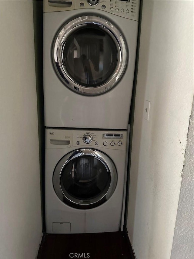 clothes washing area with stacked washer / dryer