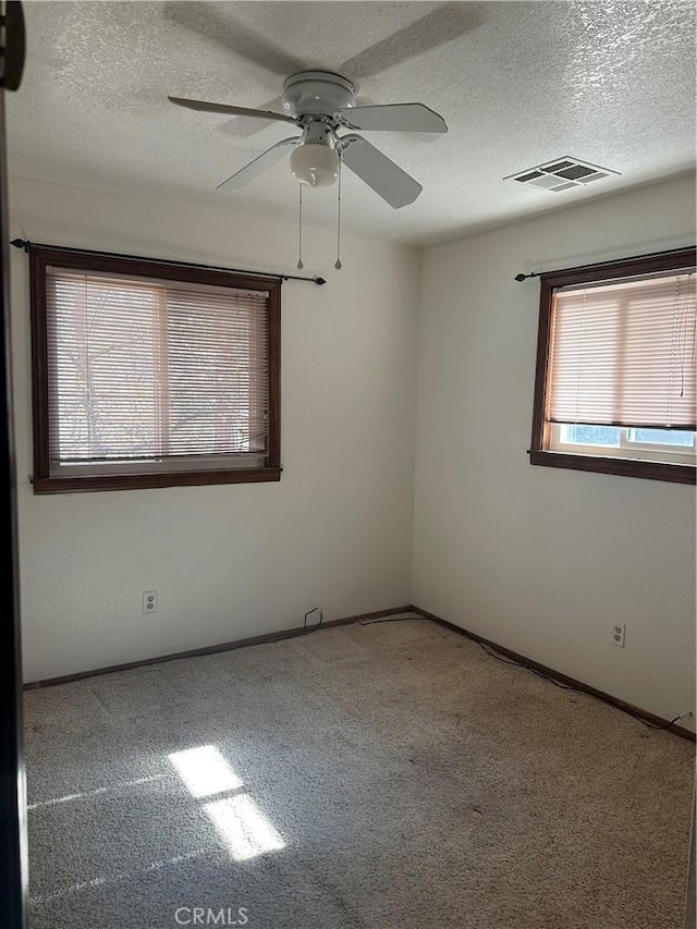 unfurnished room featuring ceiling fan, carpet, and a textured ceiling