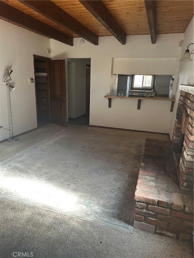 interior space featuring beam ceiling, a brick fireplace, and wood ceiling